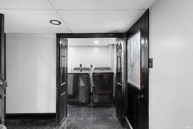 washroom featuring laundry area, baseboards, and washing machine and clothes dryer