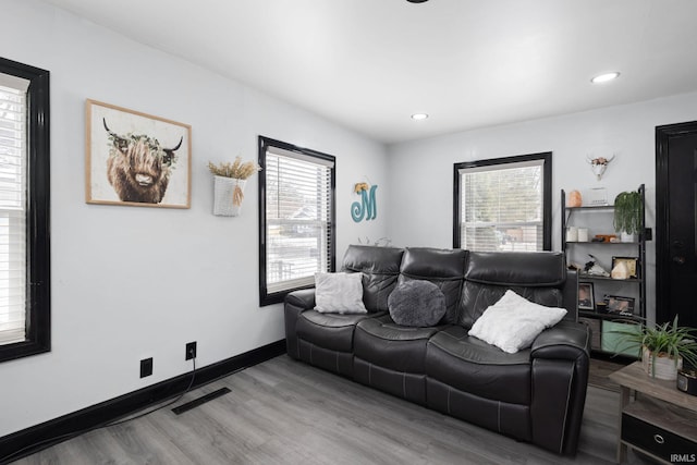 living room with recessed lighting, wood finished floors, visible vents, and baseboards