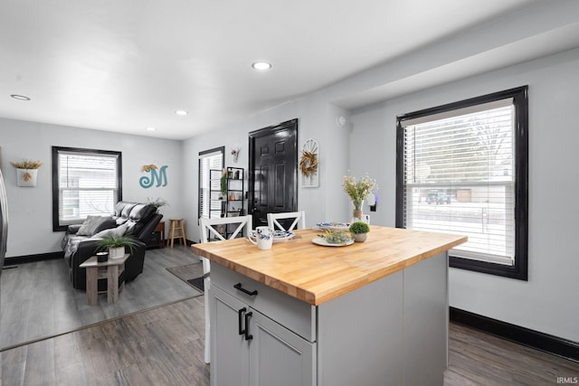 kitchen featuring butcher block countertops, open floor plan, dark wood-style flooring, and recessed lighting