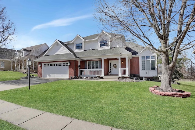 view of front facade with a porch, a front yard, brick siding, and aphalt driveway