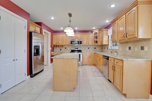 kitchen featuring light brown cabinets, a sink, a center island, appliances with stainless steel finishes, and light stone countertops