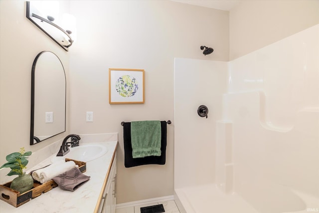 full bathroom with vanity, walk in shower, visible vents, and baseboards