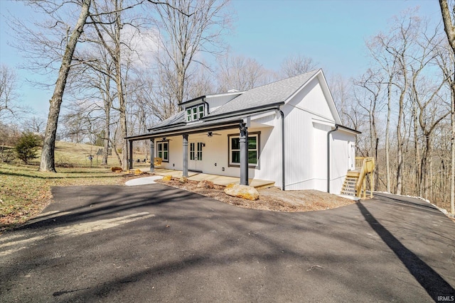 modern farmhouse style home featuring driveway, a patio area, solar panels, and a ceiling fan