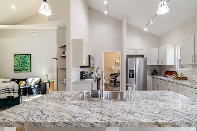 kitchen with stainless steel appliances, hanging light fixtures, a sink, and visible vents