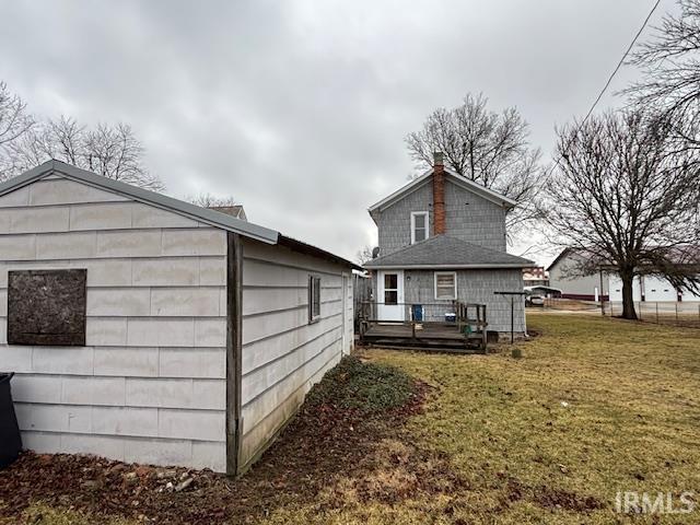 rear view of house with a lawn and a wooden deck