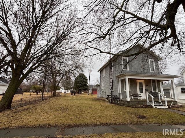 exterior space with covered porch and a front yard