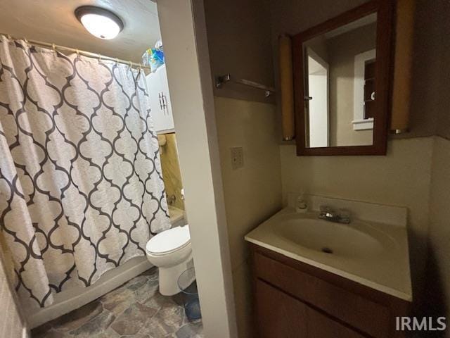 bathroom featuring vanity, toilet, and shower / bath combo with shower curtain