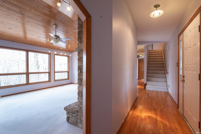 hall with stairway, baseboards, and wood finished floors