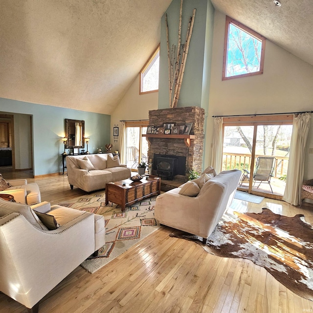 living room with high vaulted ceiling, wood-type flooring, and a textured ceiling