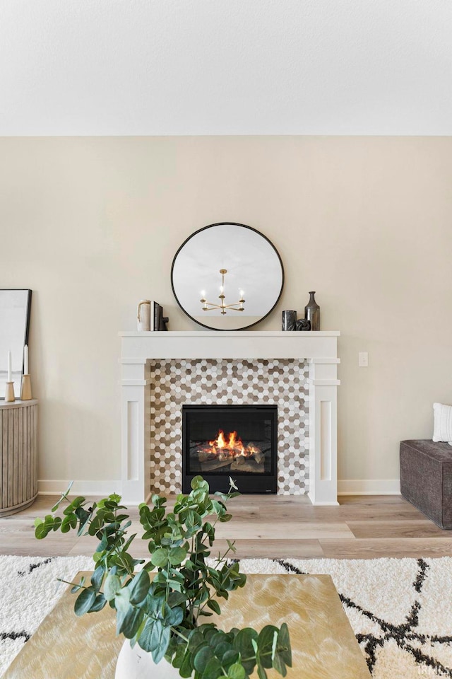 interior space featuring baseboards, a tiled fireplace, and wood finished floors