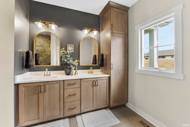 full bathroom featuring visible vents, a sink, baseboards, and double vanity