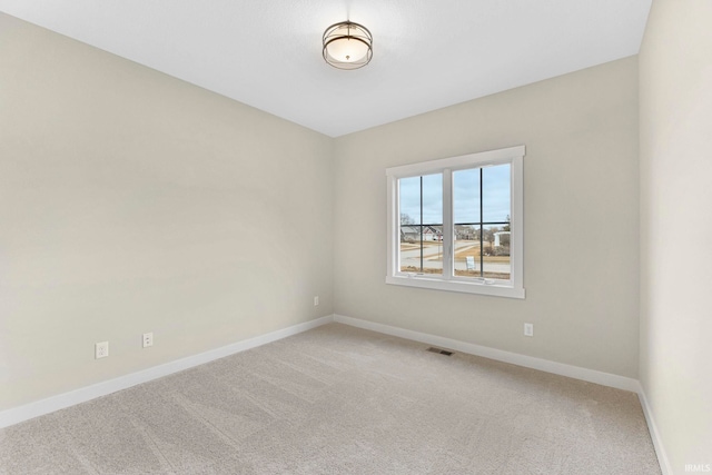 spare room with visible vents, baseboards, and light colored carpet