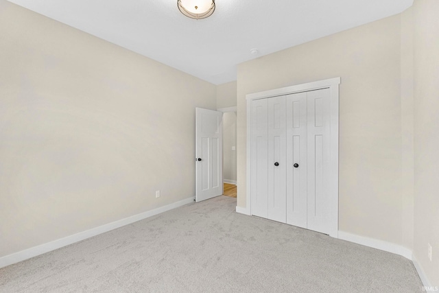 unfurnished bedroom with a closet, carpet flooring, and baseboards