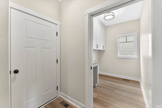 doorway featuring visible vents, light wood-style flooring, and baseboards