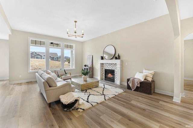 living area with light wood finished floors, a fireplace, and baseboards