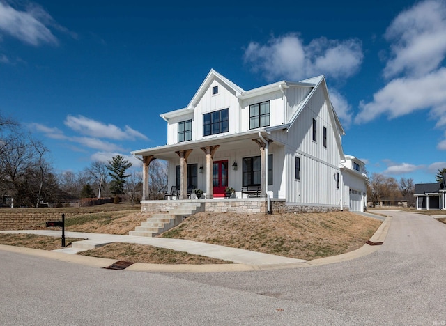 modern inspired farmhouse with a porch, an attached garage, and board and batten siding