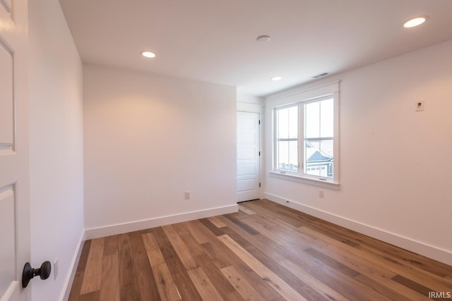 spare room featuring visible vents, recessed lighting, wood finished floors, and baseboards