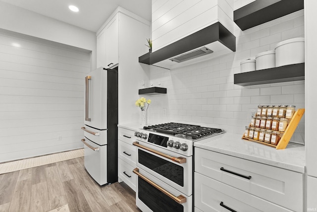 kitchen featuring premium range hood, white appliances, white cabinets, light wood-type flooring, and open shelves