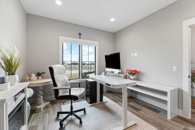 office space with recessed lighting, light wood-style flooring, and baseboards