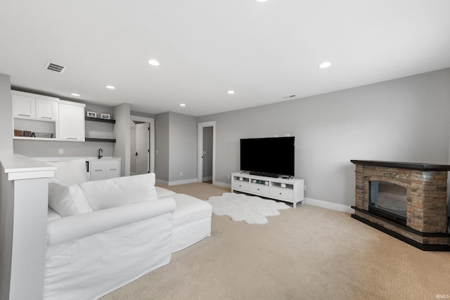 living room with a fireplace, recessed lighting, visible vents, light carpet, and baseboards