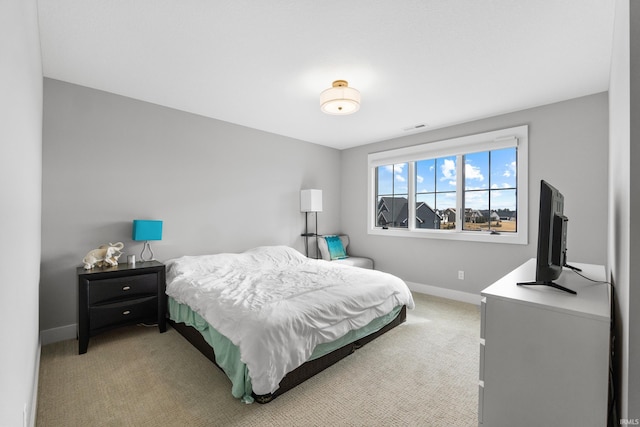 bedroom with visible vents, light colored carpet, and baseboards