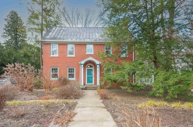 colonial-style house featuring brick siding