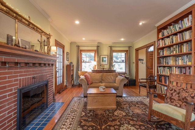 living room featuring crown molding, a fireplace, hardwood / wood-style floors, and recessed lighting