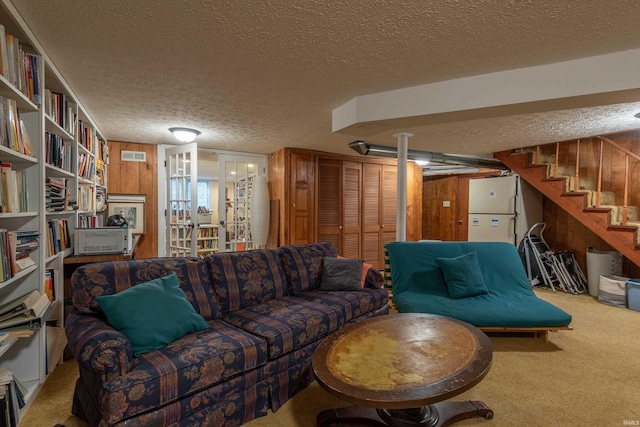 living area featuring a textured ceiling, carpet, visible vents, and wooden walls