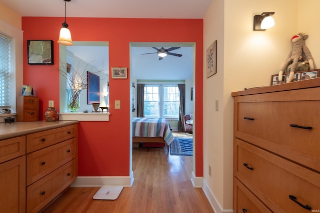 hallway featuring light wood-type flooring and baseboards