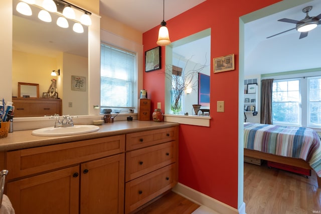 ensuite bathroom with vanity, a ceiling fan, connected bathroom, and wood finished floors