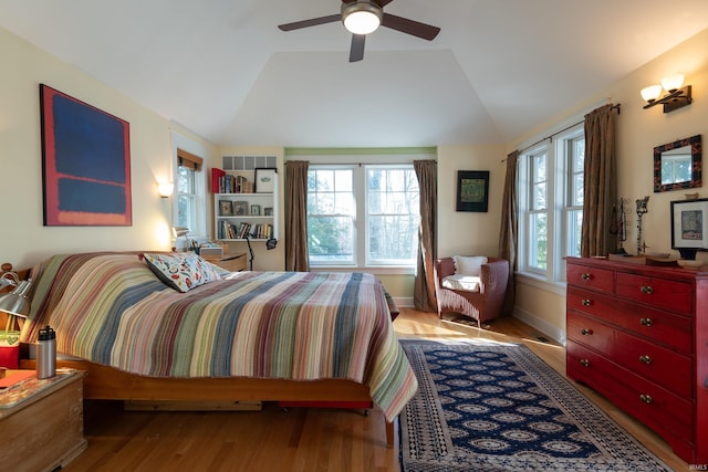 bedroom with lofted ceiling, ceiling fan, baseboards, and wood finished floors