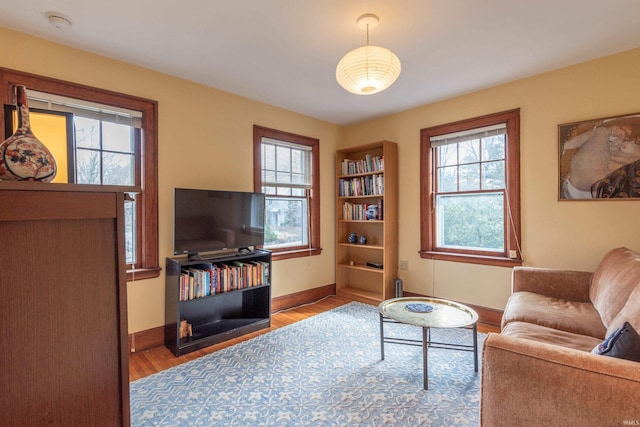 living area with baseboards and wood finished floors