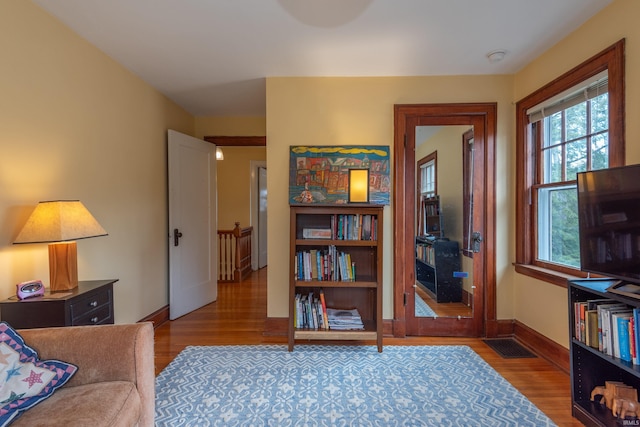 sitting room featuring visible vents, baseboards, and wood finished floors