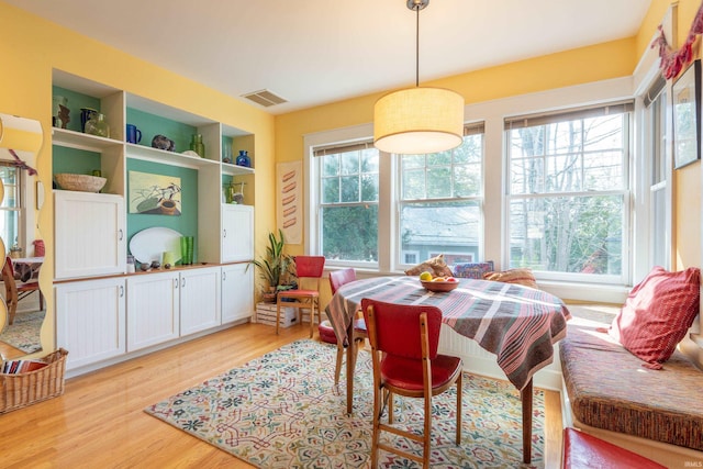 dining area with built in features, visible vents, and light wood-style floors