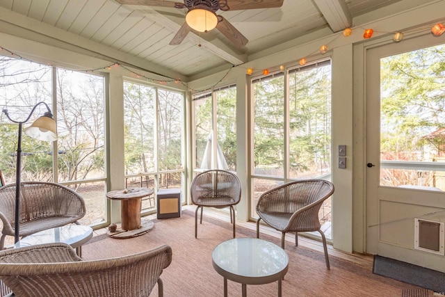 sunroom / solarium featuring a ceiling fan, wood ceiling, and beamed ceiling