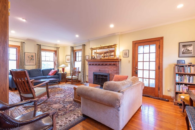 living room featuring ornamental molding, a brick fireplace, wood finished floors, and recessed lighting