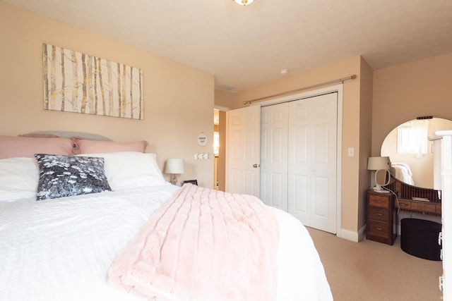 bedroom with a closet, baseboards, and carpet