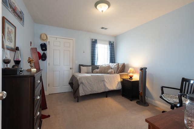 bedroom with visible vents, light colored carpet, and baseboards