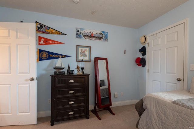 bedroom with baseboards and light colored carpet