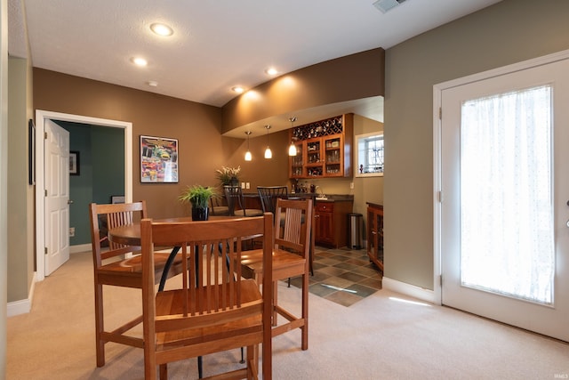 dining space with recessed lighting, light colored carpet, and baseboards