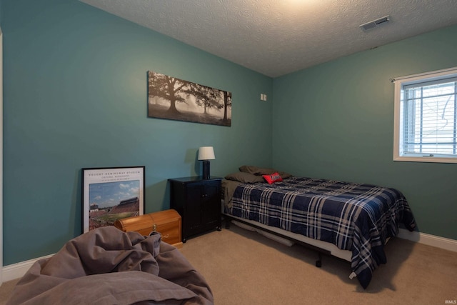 bedroom with visible vents, carpet flooring, a textured ceiling, and baseboards