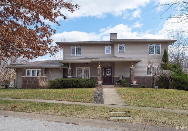 traditional-style house with brick siding, covered porch, and a front yard