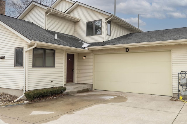 view of front of home with concrete driveway, roof with shingles, and an attached garage