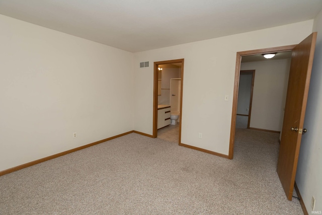 unfurnished bedroom featuring light carpet, visible vents, baseboards, and ensuite bathroom