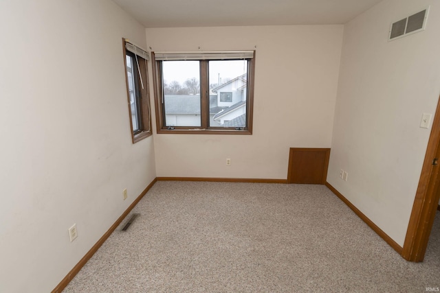 empty room featuring carpet floors, visible vents, and baseboards