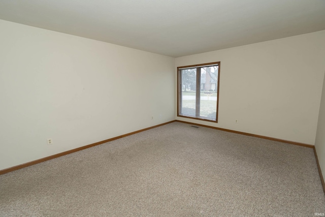 empty room featuring light carpet, visible vents, and baseboards