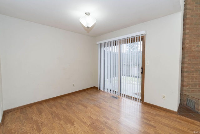 spare room with visible vents, light wood-style flooring, and baseboards