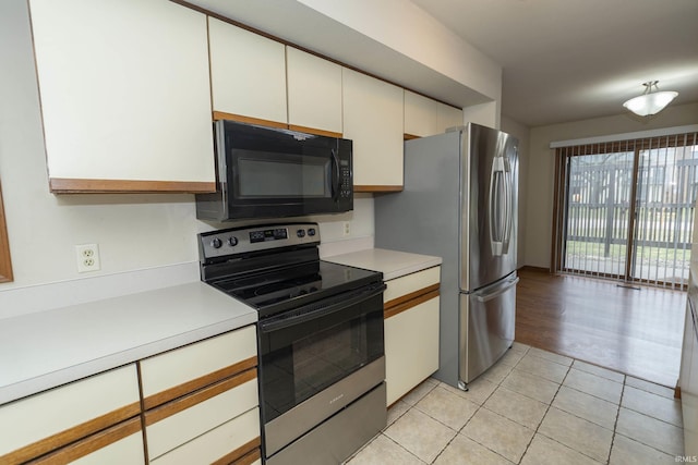 kitchen with white cabinetry, stainless steel appliances, light countertops, and light tile patterned flooring