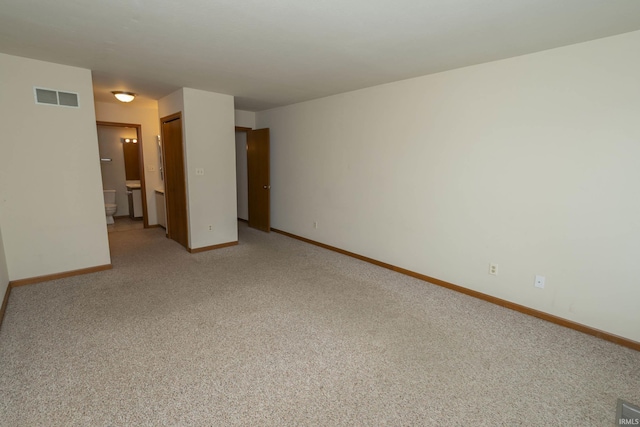 empty room with baseboards, visible vents, and light colored carpet