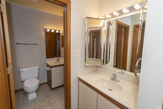 bathroom featuring tile patterned flooring, baseboards, vanity, and toilet